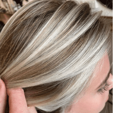 pulling blonde hair back to showcase highlights