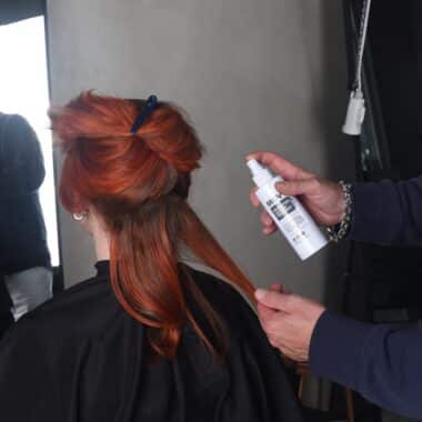 Revolution Spray being applied to red hair during styling