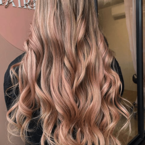 Long flowing and wavy hair that is golden blonde with pastel pink throughout