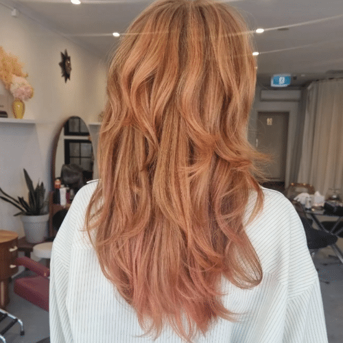 Woman with long, natural red hair with subtle pink tones through the ends